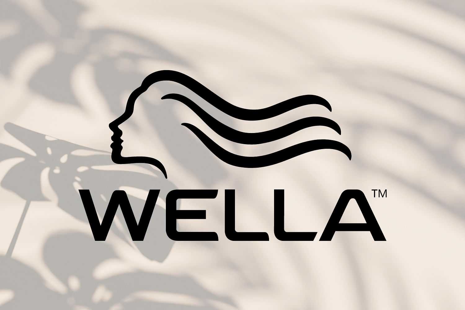 Wella logo with a silhouette of a woman's head and flowing hair, shadowed by leaves in the background.